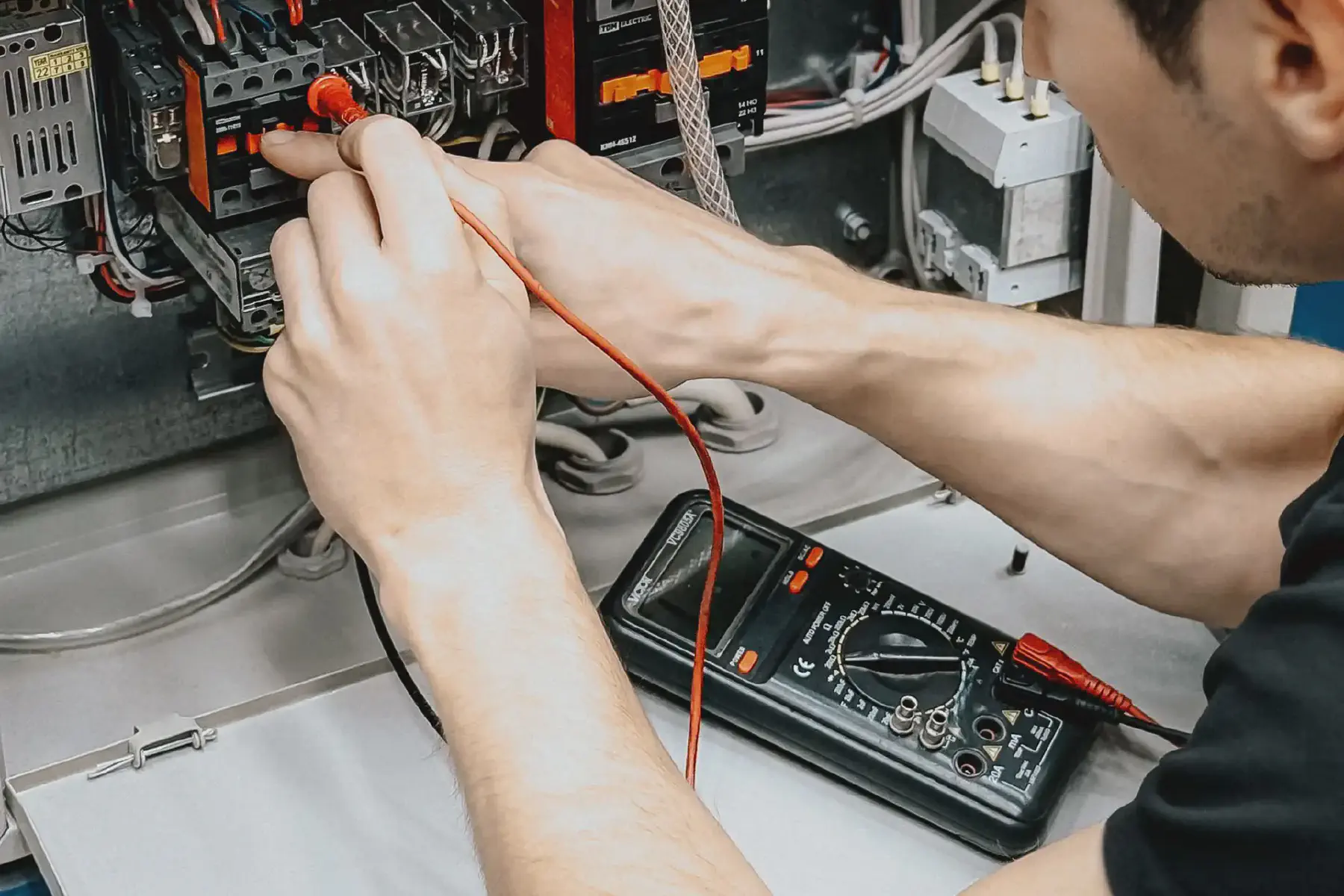 An electrician testing a circuit with a digital multimeter